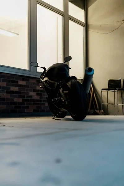 Czarny Motocykl Zaparkowany Przy Oknie — Zdjęcie stockowe