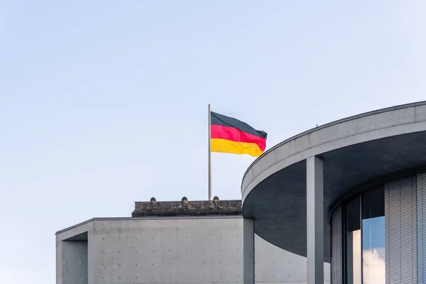 在德国柏林的一座建筑物上 在多云的天空中 一根杆子上飘扬着德国国旗 — 图库照片