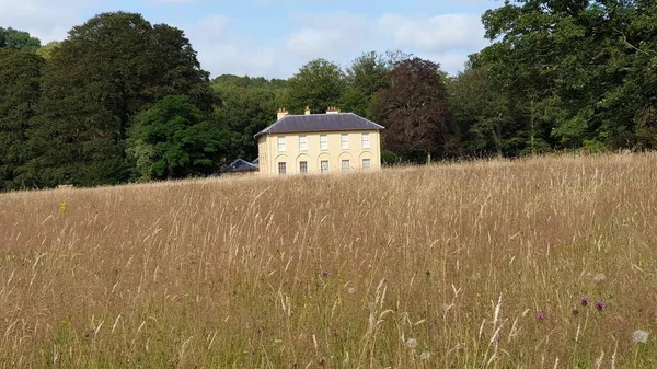 Uma Casa Meio Campo Com Colinas Fundo Sob Céu Azul — Fotografia de Stock