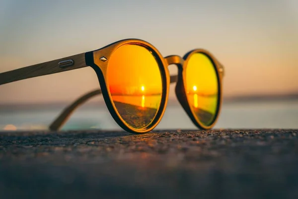 해변에서 석양을 반사하는 선글라스 — 스톡 사진