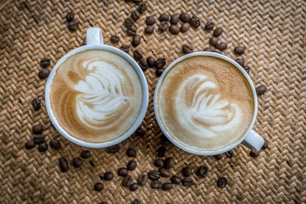 Eine Hochauflösende Aufnahme Von Zwei Tassen Cappuccino Mit Kaffeekunst Und — Stockfoto