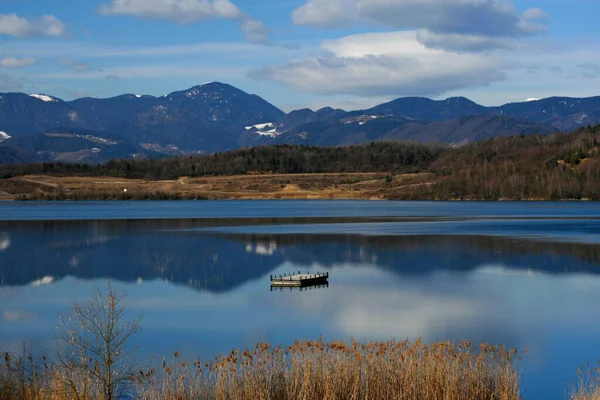 Jezero Obklopené Kopci Pokrytými Zelení Odrážející Vodě Pod Slunečním Světlem — Stock fotografie