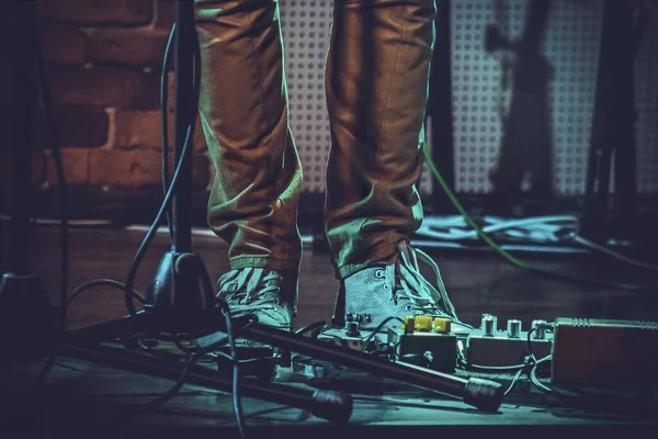 靠近吉他手踏板的人的脚的特写和灯光下的麦克风支架 — 图库照片