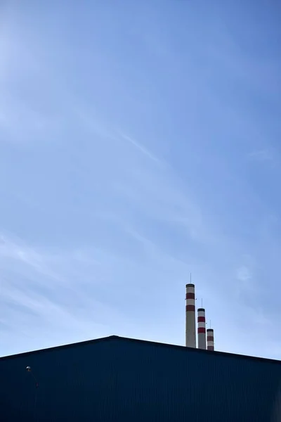 Eine Vertikale Aufnahme Von Fabriktürmen Und Dem Blauen Himmel Hintergrund — Stockfoto