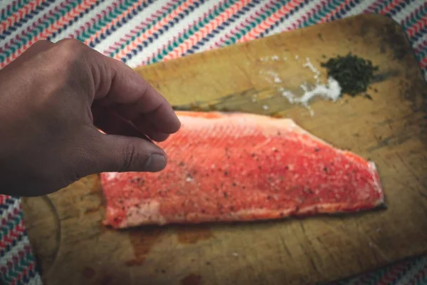 Uma Pessoa Adicionando Sal Pimenta Pedaço Salmão — Fotografia de Stock