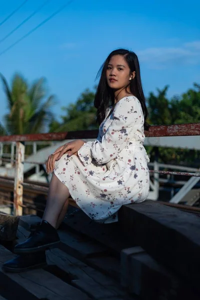 橋の上に座っている黒い髪のベトナム人の少女 — ストック写真