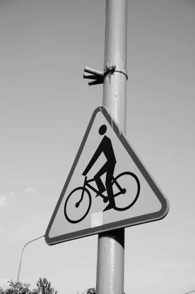 ポールに自転車のシンボルが付いている道路標識の垂直グレースケールのクローズアップショット — ストック写真