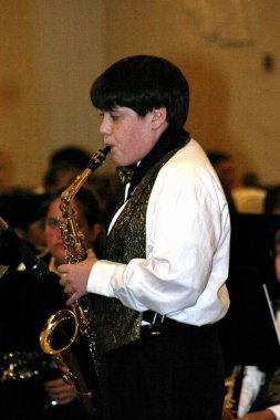 MEMPHIS, UNITED STATES - May 20, 2006: Young saxophonist performs solo at school concert. clipart