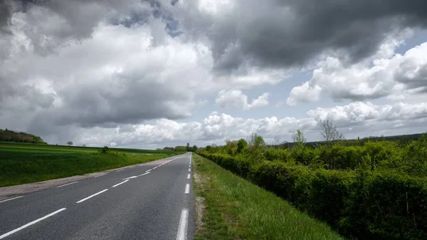 Een Snelweg Omringd Door Groene Vallei Onder Donkere Bewolkte Lucht — Stockfoto