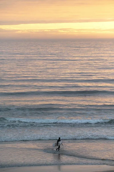 Plano Vertical Una Persona Con Una Tabla Surf Caminando Por —  Fotos de Stock