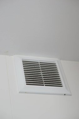 A low angle shot of a ventilator window on a white wall clipart