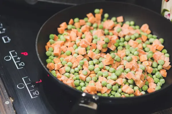 Een Close Schot Kubusvormige Wortelen Groene Erwten Een Zwarte Pan — Stockfoto