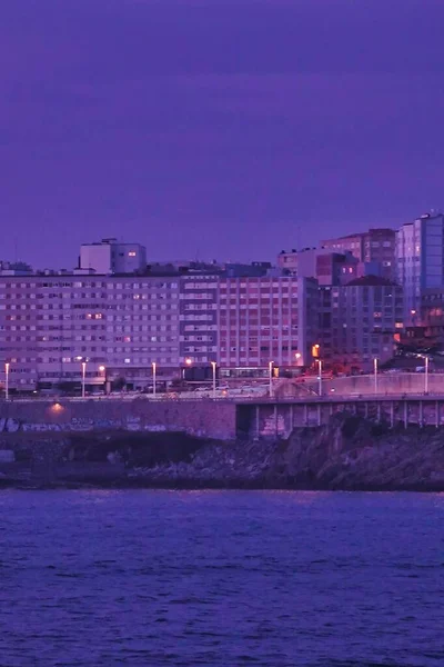 西班牙科鲁纳市夜晚靠近大海的住宅建筑的垂直图片 — 图库照片
