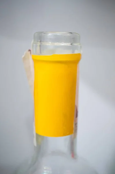 Tiro Vertical Close Uma Garrafa Vidro Transparente Com Fita Amarela — Fotografia de Stock