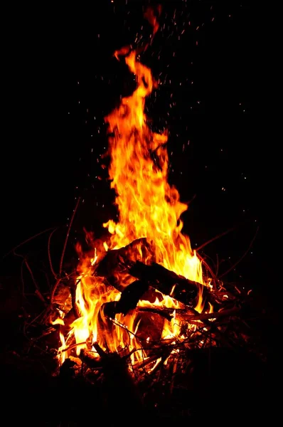 Eine Vertikale Aufnahme Eines Lodernden Feuers Mit Schwarzem Hintergrund — Stockfoto