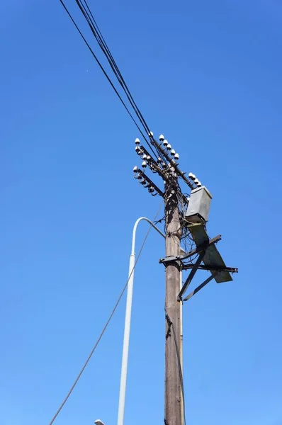 背の高い木製の電気マストは青空を背景に — ストック写真