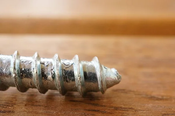 Plan Rapproché Extrémité Pointue Une Vis Argentée Sur Une Table — Photo