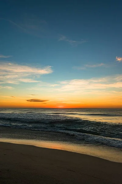 A vertical shot of the North Entrance Beach under a blue sky at sunrise