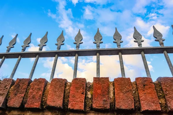 Eine Flache Aufnahme Eines Metallzaunes Oberhalb Einer Ziegelmauer — Stockfoto