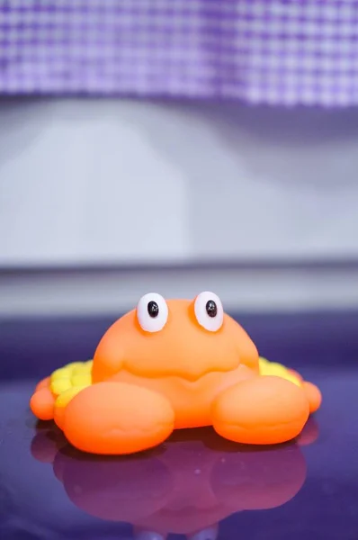 Zbliżenie Ujęcie Pomarańczowego Gumowego Kraba Zabawki Purpurowej Powierzchni — Zdjęcie stockowe