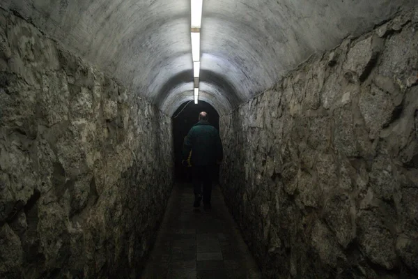 Een Man Die Een Smalle Tunnel Loopt Verlicht Met Lichten — Stockfoto
