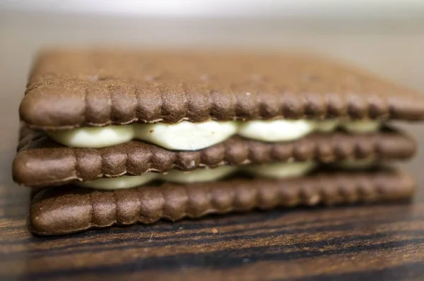 木製のテーブルの上にチョコレートサンドイッチクッキーのクローズアップ選択的フォーカスショット — ストック写真