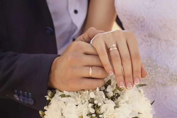 一张新婚夫妇牵着手并展示结婚戒指的特写照片 — 图库照片