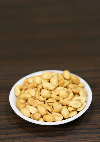 Closeup Shot Roasted Salted Peanuts Small White Bowl Wooden Table — Stock Photo, Image