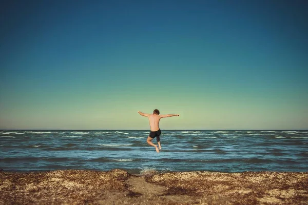 Hermoso Disparo Hombre Saltando Mar Con Una Orilla Del Mar — Foto de Stock