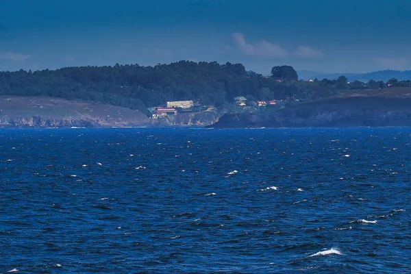 スペインのガリツィアの遠くに建物がある海の美しいショット — ストック写真