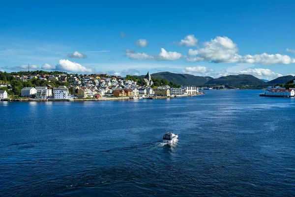 ノルウェーの太陽の下で緑と建物に覆われたキリスト教と太陽の周りの海 — ストック写真