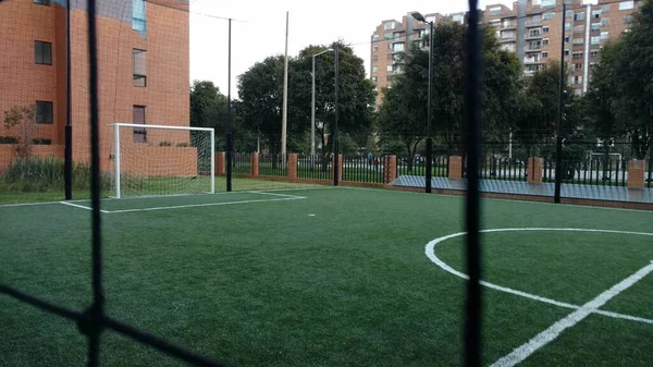 Een Voetbalveld Een Speeltuin Omringd Door Groen Gebouwen Overdag — Stockfoto