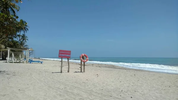 Playa Con Una Señal Precaución Ella Rodeada Vegetación Mar Bajo — Foto de Stock
