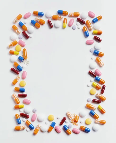 Vertikální Snímek Pilulky Rámečku Bílém Povrchu Velký Odstín Pozadí — Stock fotografie
