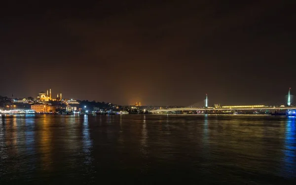 トルコのイスタンブールでの夜の間に建物や海に囲まれたSuleymaniyeモスク — ストック写真