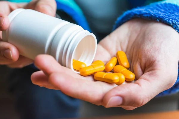 Egy Ember Sárga Tablettákat Önt Kezébe Egy Tartályból — Stock Fotó