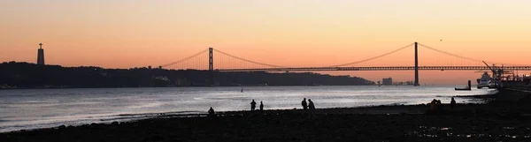 Eine Panoramaaufnahme Der Brücke Abril Gegen Den Abendhimmel Mit Silhouette — Stockfoto