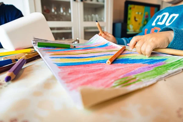 一个孩子用彩色铅笔在纸上画画 — 图库照片