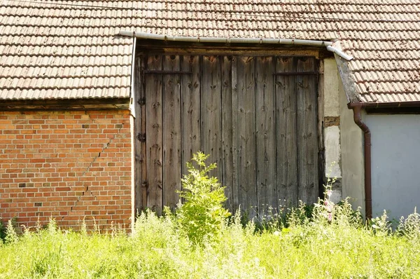 Stará Stáj Dřevěnými Dveřmi Plevelem Rostoucí Před Budovou — Stock fotografie