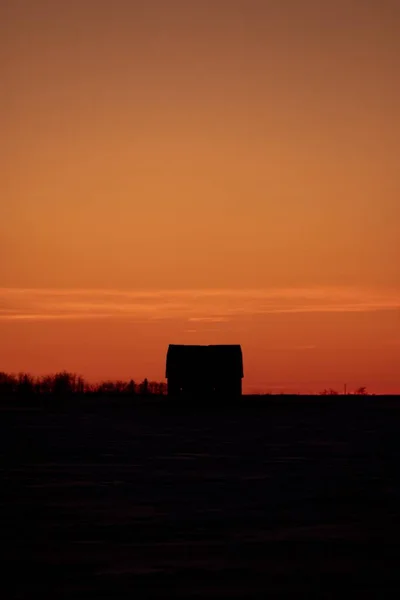 美しいオレンジ色の夕日の間の家や木のシルエット — ストック写真