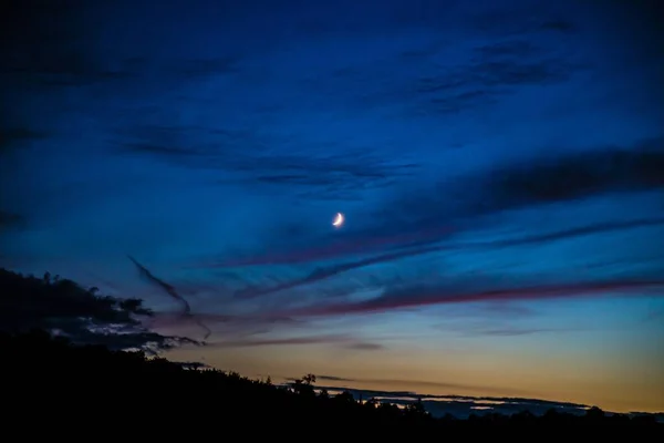 Una Luna Creciente Contra Cielo Azul Con Sol Poniente Horizonte — Foto de Stock