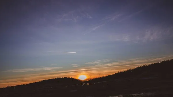 Piękny Zachód Słońca Górską Sylwetką Nad Miastem — Zdjęcie stockowe
