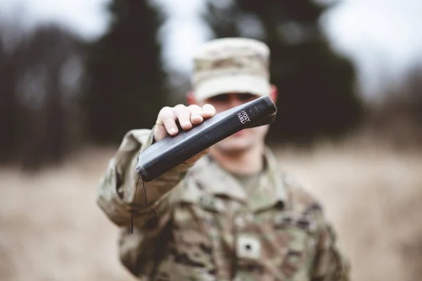 一个有选择的焦点镜头 一个拿着圣经的美国士兵靠近摄像机 — 图库照片
