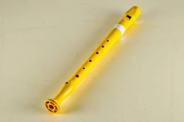 Ένα Κίτρινο Μουσικό Όργανο Τρύπες Λευκή Επιφάνεια — Φωτογραφία Αρχείου