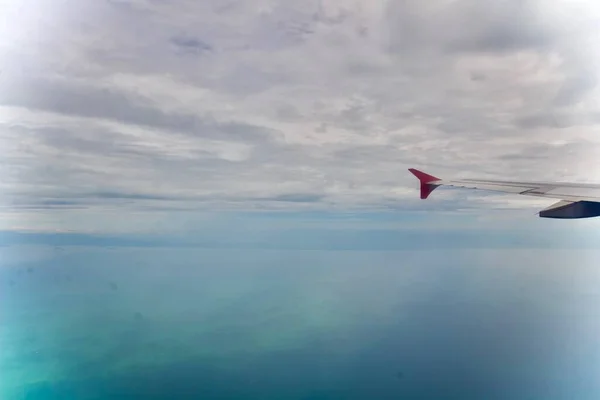 Widok Oceanu Przez Szklane Okno Samolotu Zachmurzonym Niebem Malezji — Zdjęcie stockowe