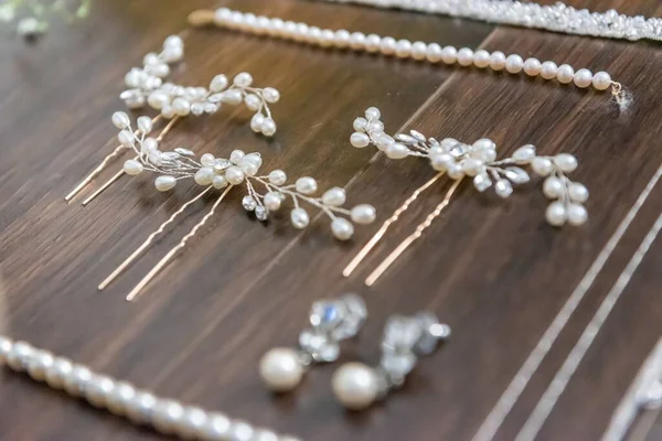 A closeup shot of beautiful white hair accessories for the bride on a wooden surface