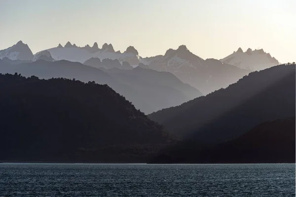Het Betoverende Uitzicht Silhouetten Van Bergen Achter Kalme Oceaan Bij — Stockfoto