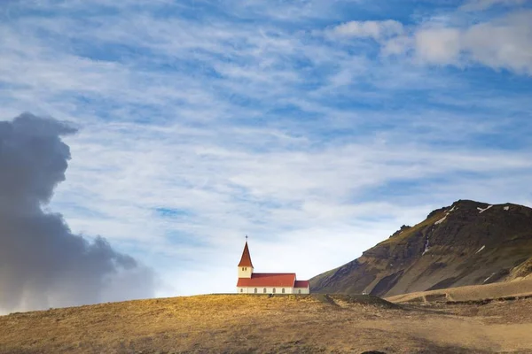 Zlanda Dağlarla Çevrili Kırmızı Beyaz Bir Kilisenin Geniş Bir Görüntüsü — Stok fotoğraf