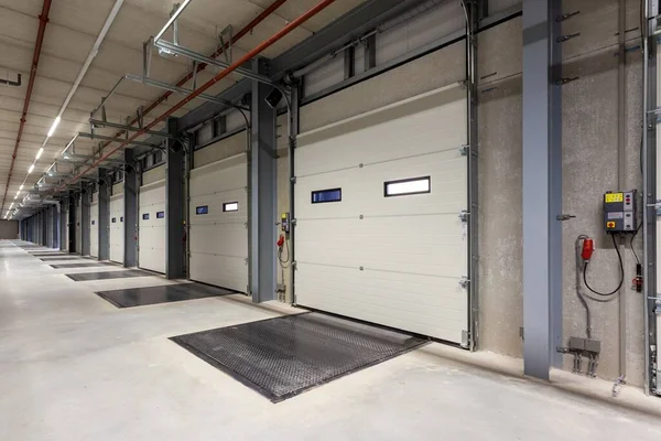 the inside of a warehouse with a row of loading bays