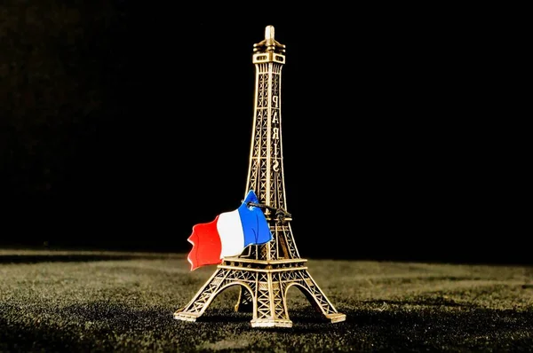 エッフェル塔のおもちゃとその隣のフランスの旗 — ストック写真